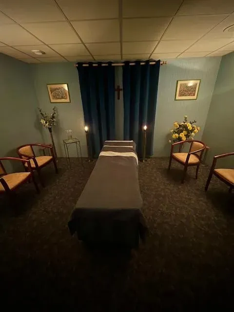 Salon funéraire intimiste aménagé avec une table de présentation et des fauteuils